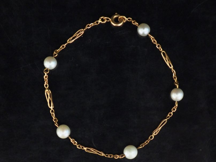 Bracelet souple en or jaune, composé de maillons ovales ajourés et per