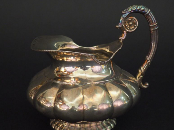 Petite verseuse en argent étranger, à décor de godrons. Anse feuillagé