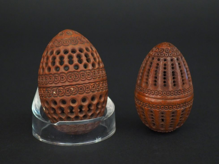 Suite de 2 œufs à chapelet en corozo à décor ajouré.