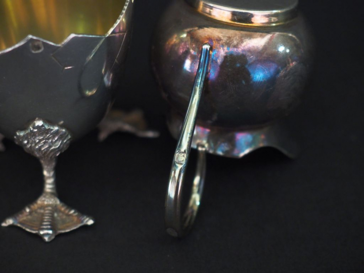 Coquetier en argent reposant sur un piètement tripode figurant des pat