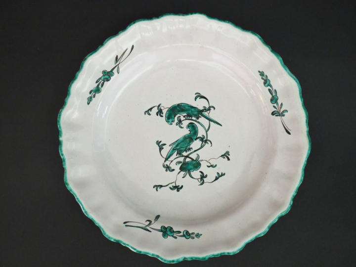 MOUSTIERS. Assiette en faïence XVIIIème à décor en camaïeu vert de per