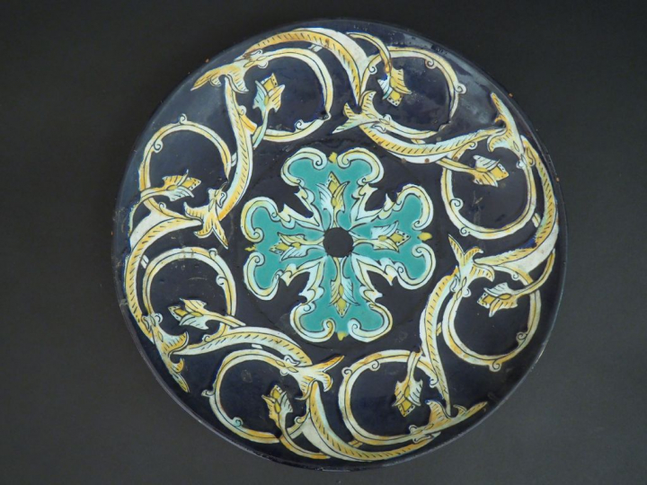 Coupe sur talon en terre vernissée et émaillée à décor de rinceaux ver