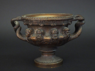 Vente aux enchères Vase à anses XIXème en bronze à patine brune à décor de huit visages d