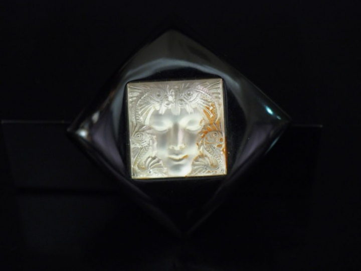 LALIQUE Broche en forme de losange en verre noir centrée d'un motif de