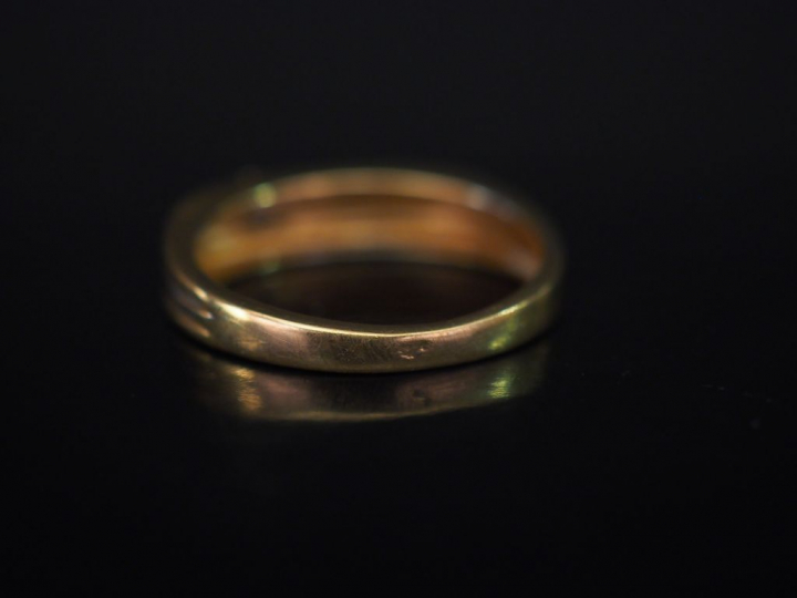 Bague de forme stylisée trois tons d'or, sertie d'un petit diamant.  T