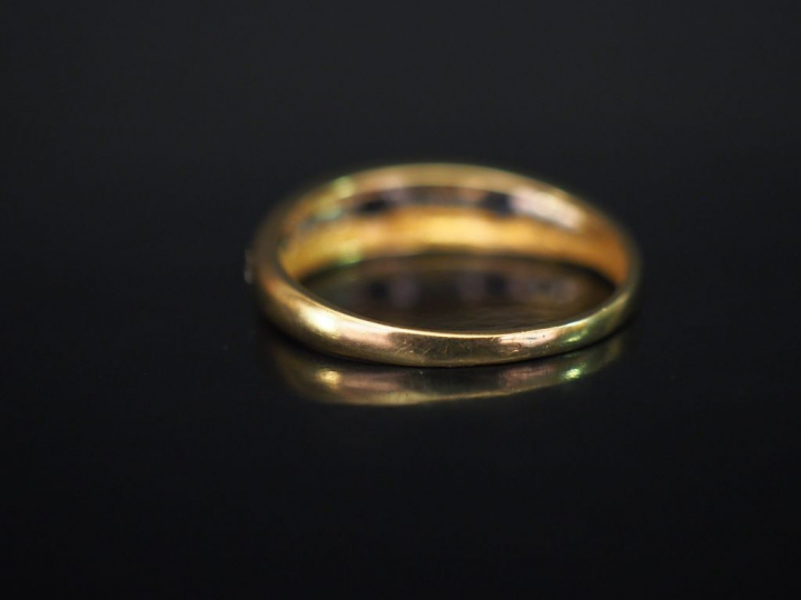 Demi-alliance en or jaune, sertie de pierres bleues calibrées et petit