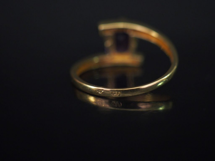 Bague de forme stylisée en or jaune, sertie d'une pierre mauve. TDD. 6