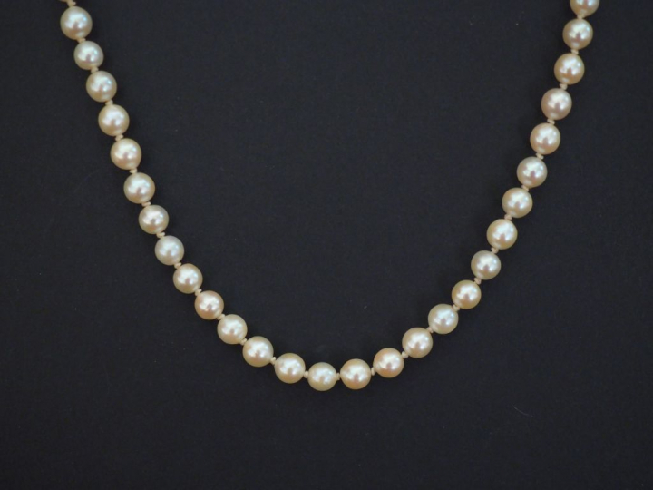 Collier de perles blanches.  Chainette de sécurité en or jaune.  Fermo