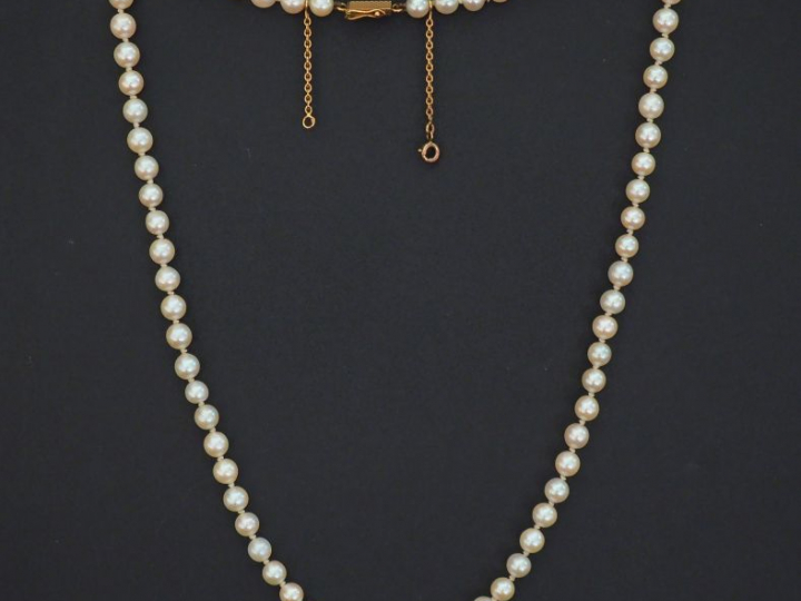 Collier de perles blanches.  Chainette de sécurité en or jaune.  Fermo