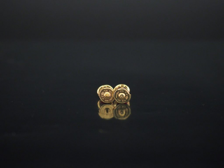 Paire de puces d'oreilles en or jaune, serties d'un rubis (?). Fermoir