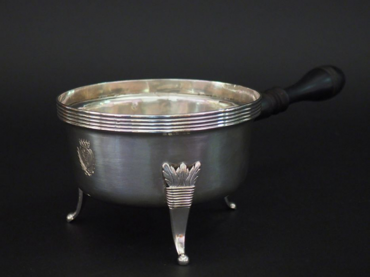 Casserole en argent, manche en bois noirci. Reposant sur trois pieds à