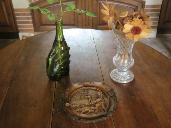 Assiette murale décorative en bois sculpté. Un pichet en verre en form