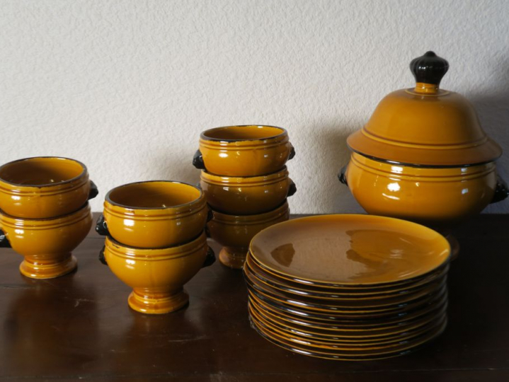 Partie de service de table en terre vernissée jaune.