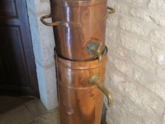 Vente aux enchères Distillateur en cuivre, fonte et laiton. H. 137 cm.