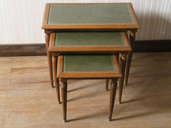 Trois tables gigognes de style Louis XVI, pieds fuselés, dessus cuir.