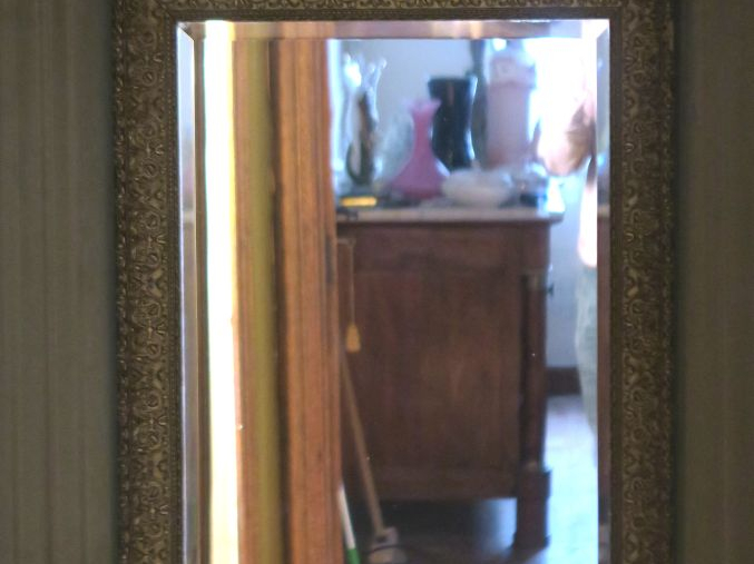 Un miroir en bois et stuc doré à décor de glands. Dim. 78 x 62 cm. (Sa