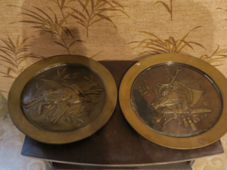 Vente aux enchères Paire de plaques murales décoratives en laiton repoussé à décor de tro