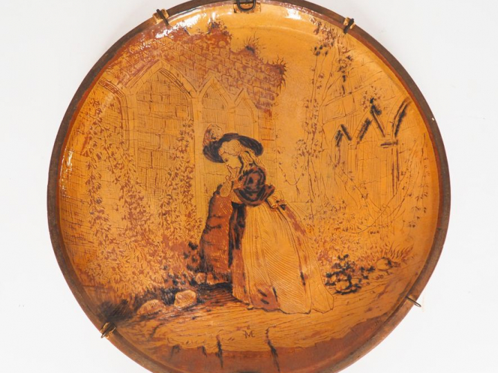 Grand plat rond fin XIXème en terre vernissée à décor d'une jeune élég