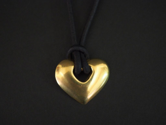 Vente aux enchères Collier orné d'un pendentif en or jaune ajouré, en forme de cœur. Cord