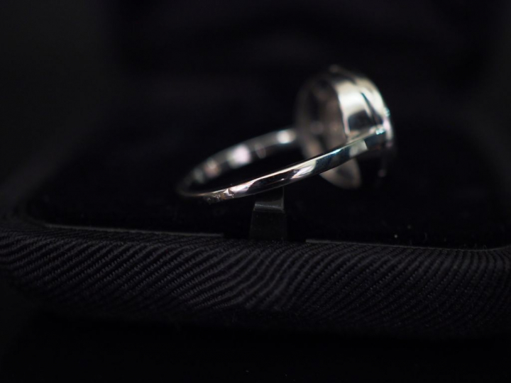 Bague ronde en or blanc, sertie en son centre d'un éclat de diamant en