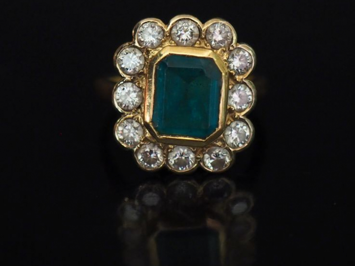 Bague de forme marguerite en or jaune, sertie en son centre d'une émer