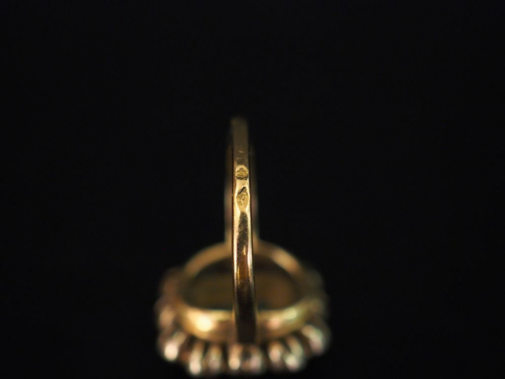 Bague de forme marguerite en or jaune, sertie en son centre d'une émer