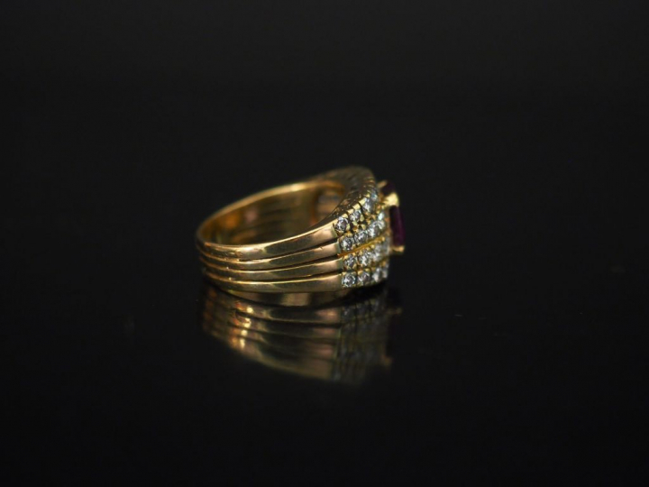 Bague en or jaune, sertie en son centre d'une pierre rose épaulée d'un