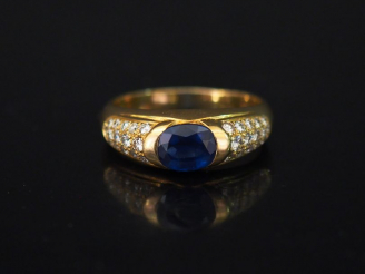 Vente aux enchères Bague jonc en or jaune, sertie en son centre d'une pierre bleue épaulé