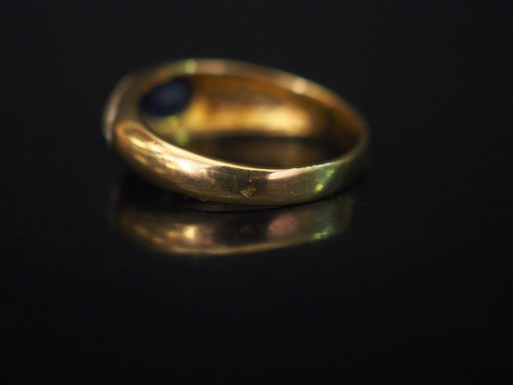 Bague jonc en or jaune, sertie en son centre d'une pierre bleue épaulé