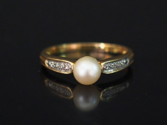 Vente aux enchères Bague en or jaune, sertie en son centre d'une perle blanche épaulée de