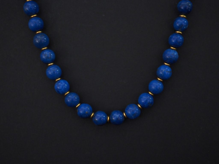 Collier de perles de lapis lazuli, fermoir menotte en or jaune. Long. 