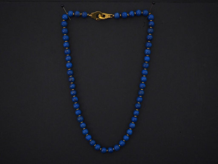 Collier de perles de lapis lazuli, fermoir menotte en or jaune. Long. 