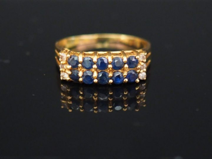 Bague pont en or jaune, sertie de deux lignes de pierres bleues et de 