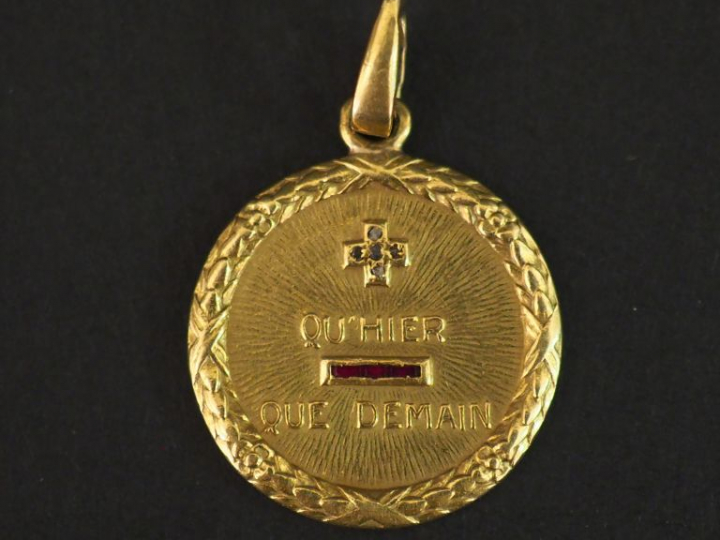 Médaille en or jaune, éclats de diamants et pierres roses marquée "+ q