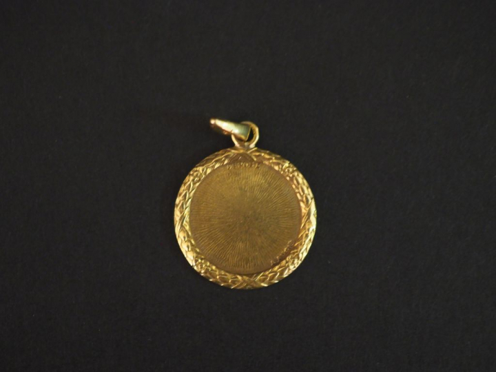 Médaille en or jaune, éclats de diamants et pierres roses marquée "+ q