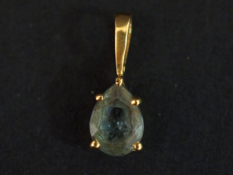 Vente aux enchères Petit pendentif en or jaune, serti d'une pierre bleu ciel en forme de 