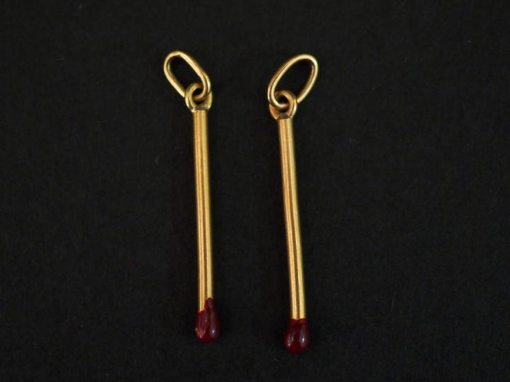 Deux pendentif en or jaune et émail rouge, en forme d'allumettes. H. 2
