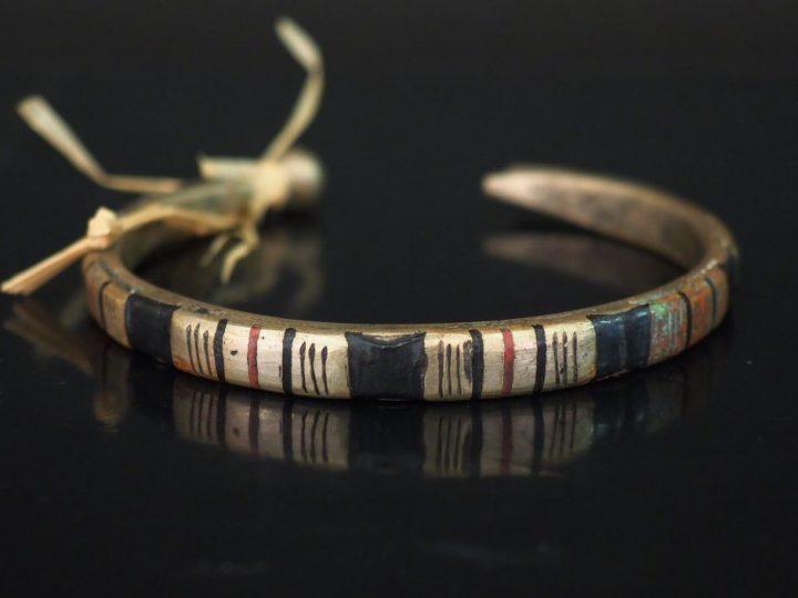 Bracelet en métal figurant un serpent, rehaussé d'émail noir et rouge.