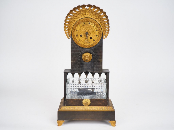 Pendule Charles X en bronze patiné, doré et cristal, en forme de fonta