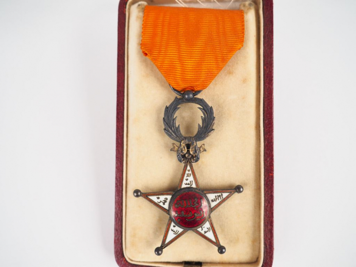 Boite d’origine contenant sur fond crème une étoile de l’ordre marocai