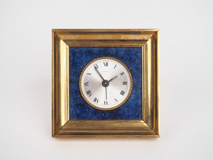CARTIER. Réveil en laiton et Lapis-lazuli à décor d'une frise de perle