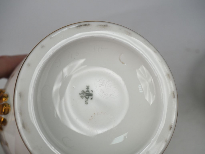 SEVRES. Verseuse et assiette en porcelaine à décor de rinceaux dorés e
