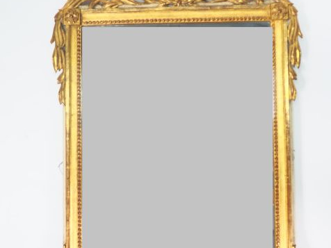 Miroir de style Louis XVI en bois et stuc doré à décor de rinceaux, su