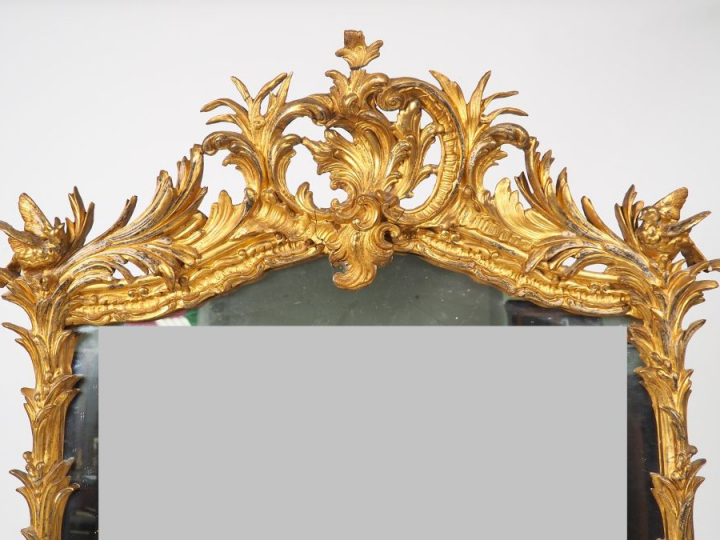 Miroir Louis XV en bois et stuc doré à décor feuillagé, surmonté d'un 