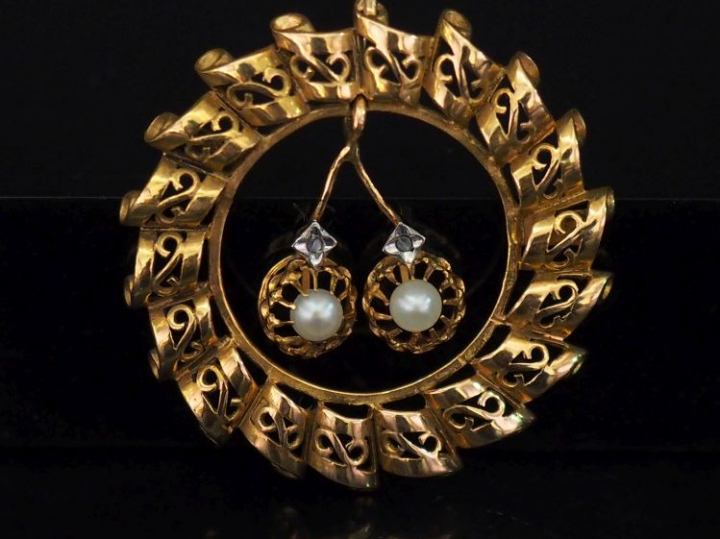 Pendentif circulaire en or ajouré, à décor de consoles et agrémenté d'