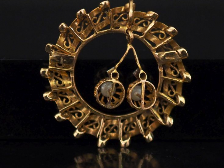 Pendentif circulaire en or ajouré, à décor de consoles et agrémenté d'