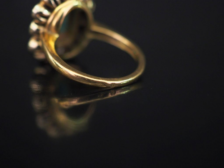 Bague de forme marguerite en or jaune, sertie en son centre d'une émer