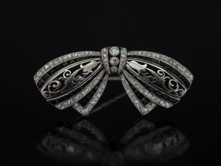 JANESICH, à Paris Broche nœud en platine, à décor ajouré de rinceaux f