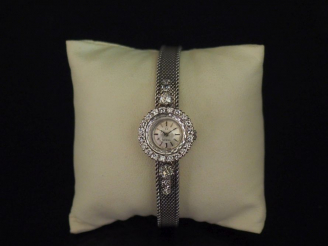 Vente aux enchères OMEGA.  Montre de dame en platine, cadran orné de diamants et bracelet
