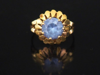 Vente aux enchères Bague marguerite en or jaune et quartz bleu, élégante monture ajourée.